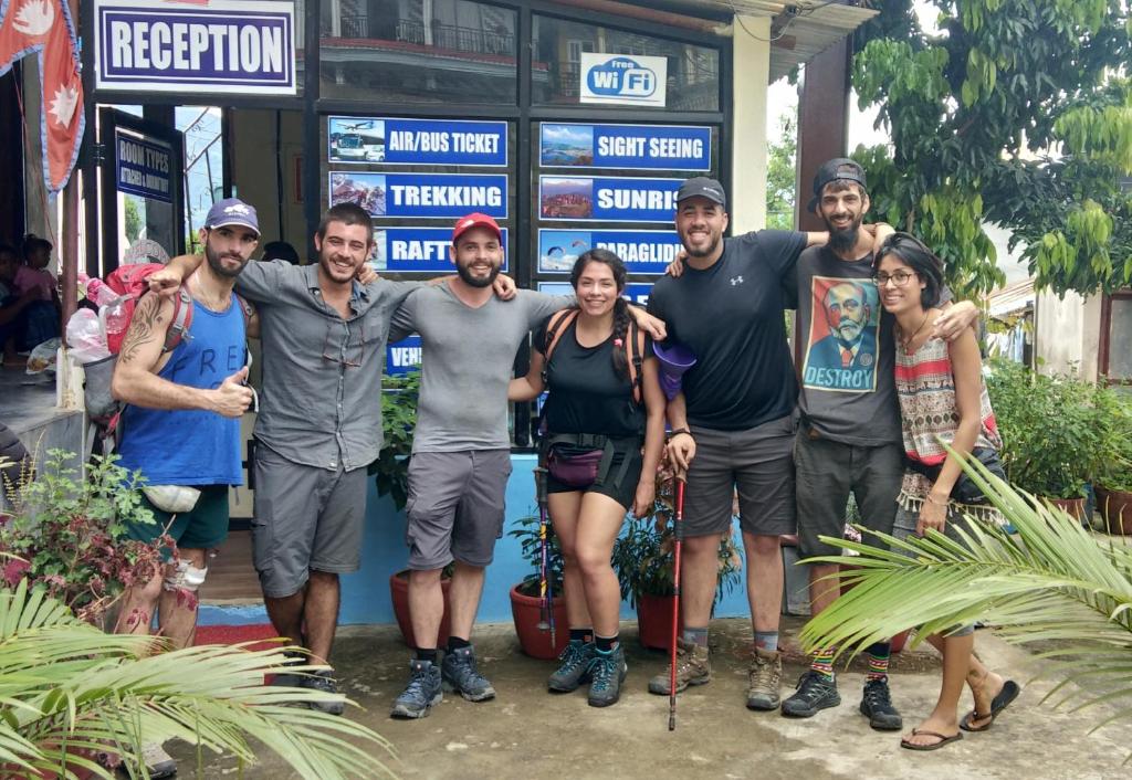 a group of people standing in front of a sign at Pokhara Youth Hostel in Pokhara