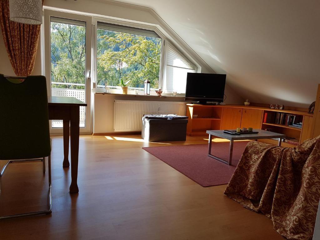 ein Wohnzimmer mit einem großen Fenster und einem Tisch in der Unterkunft Stürmlesloch in Bad Wildbad