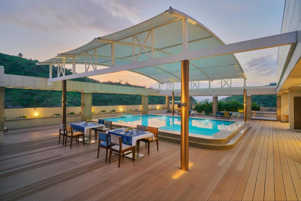 a pool on a deck with tables and chairs at Blu Feather Hotel & Spa in Udaipur