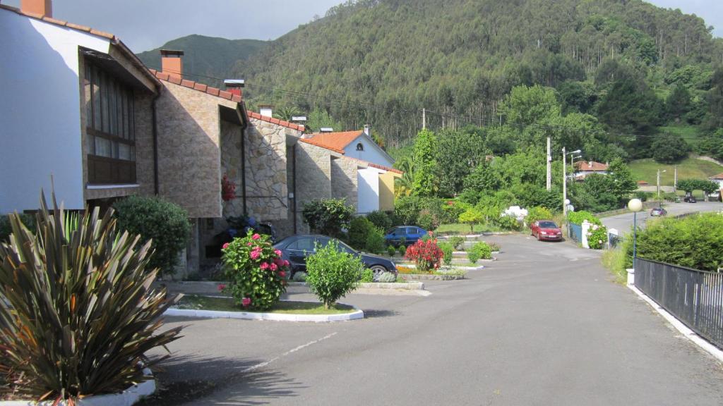 une rue dans une petite ville avec une montagne dans l'établissement Urbanización La Barria 115, à Nueva de Llanes