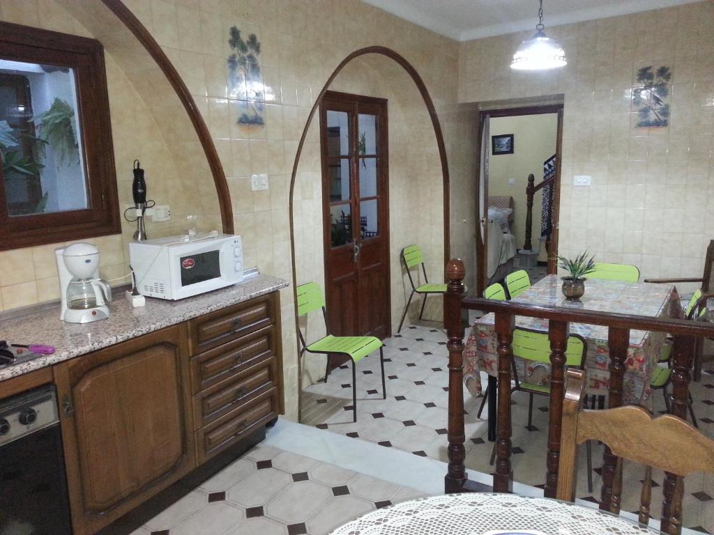 a kitchen with a microwave and a table and chairs at Casa Rural La Verdura in Ubrique