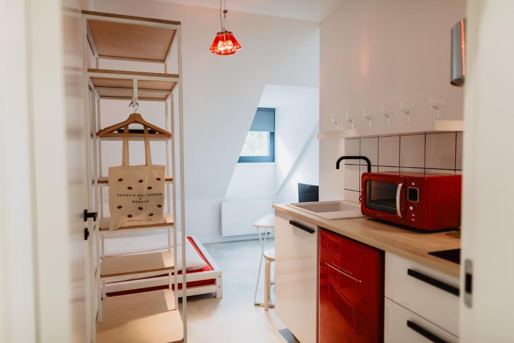 una cocina con microondas rojo en una encimera en Street Food Possonium Apartments, en Bratislava