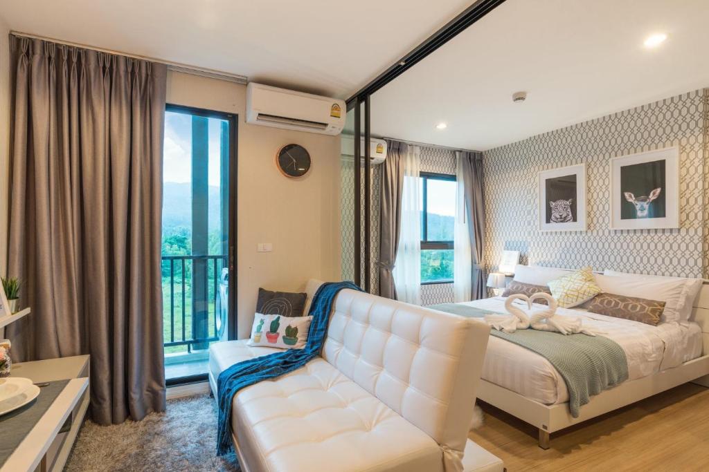 a bedroom with a white bed and a couch at Bangtao,Layan beach apartment in Bang Tao Beach