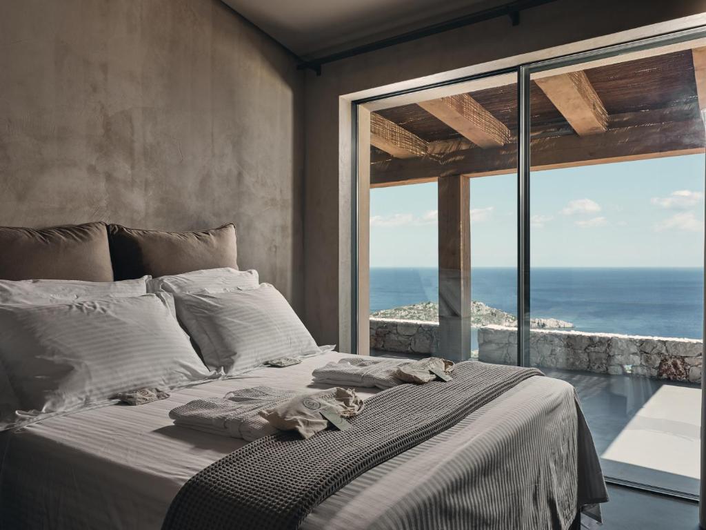 a bedroom with a bed with a view of the ocean at Vais Luxury Villas in Agios Nikolaos