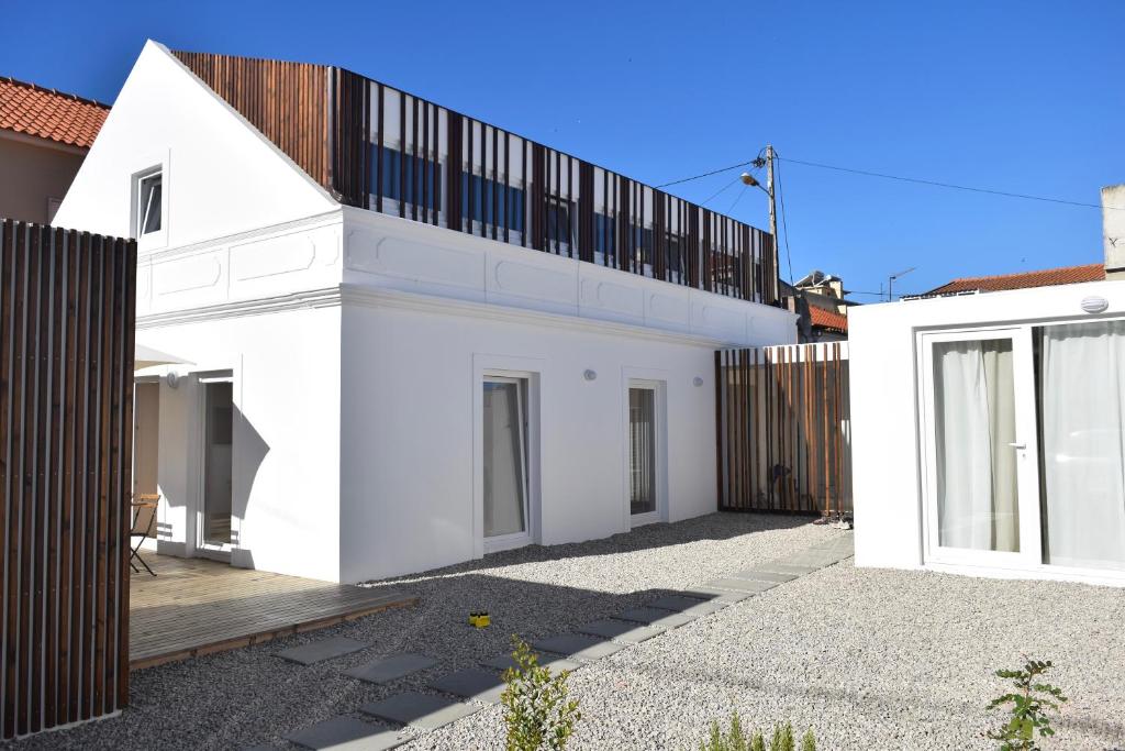 une maison blanche avec un toit noir dans l'établissement Fisherman's House - a boat ride from Lisbon, à Trafaria