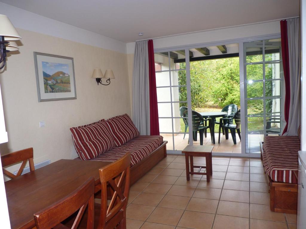 ein Wohnzimmer mit einem Sofa und einem Tisch in der Unterkunft N23, parc d'arradoy-St J P de Port in Uhart-Cize
