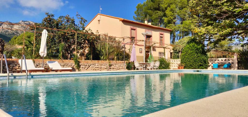 a swimming pool in front of a house at Casa de Los Lirios in Muro de Alcoy