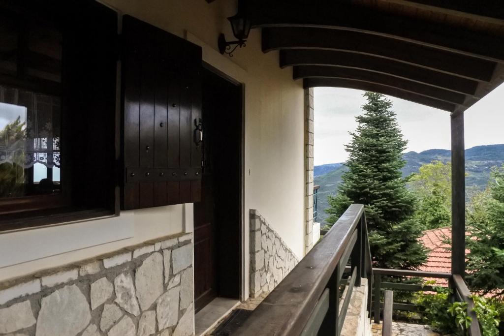 una porta aperta su un balcone con vista su un albero di Υάς Residence a Kato Trikala Korinthias