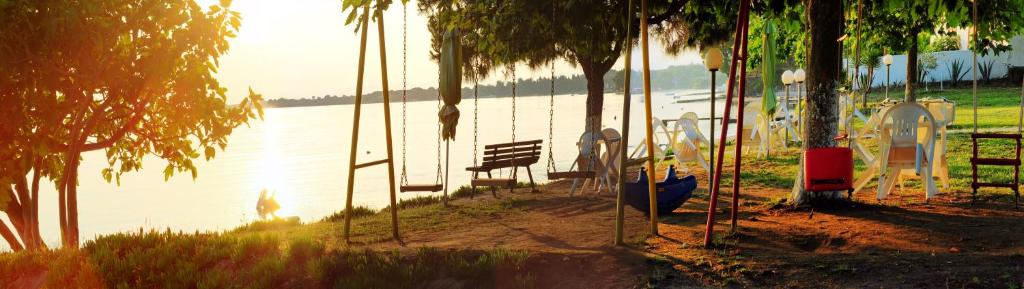 a swing with a bench next to a body of water at Emi House in Vourvourou