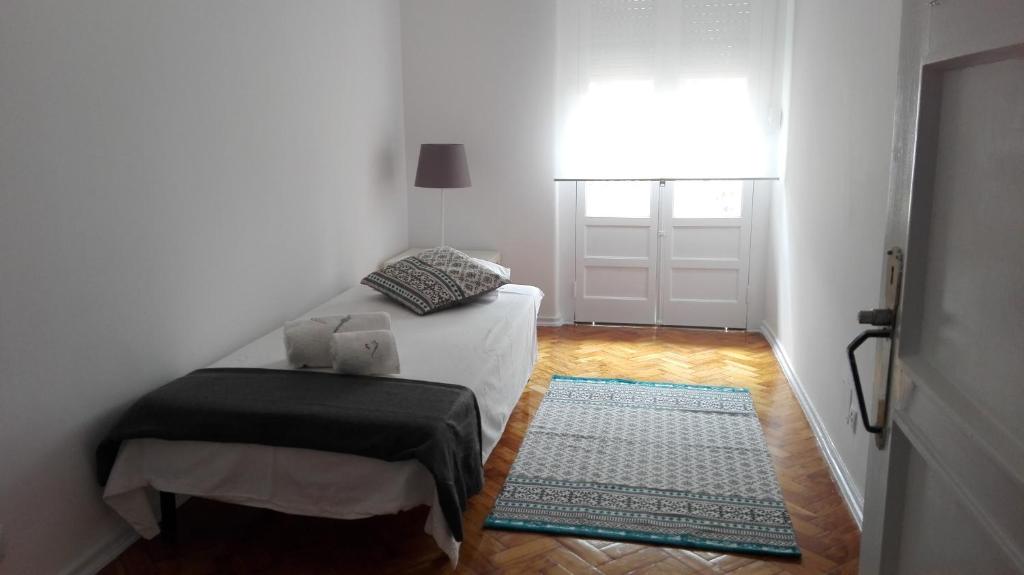 een slaapkamer met een bed, een raam en een deur bij Golden Apartment City Center in Lissabon