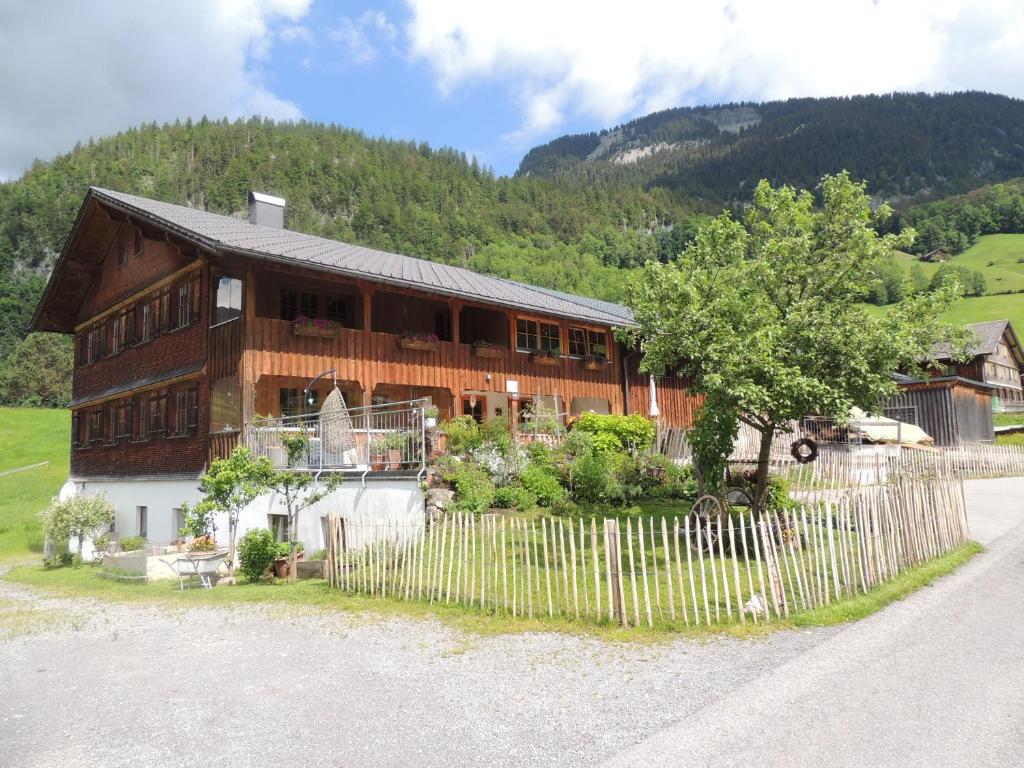a wooden house with a fence in front of it at Rüf Stefanie in Au im Bregenzerwald