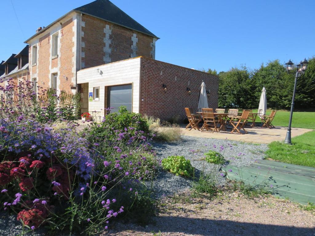 un jardin fleuri devant un bâtiment dans l'établissement Chambres d'hôtes La Mare aux Saules, à Sausseuzemare-en-Caux