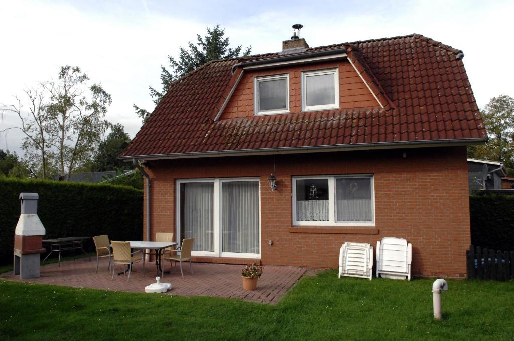 une maison avec une table et des chaises dans la cour dans l'établissement Seemöwe, à Bedekaspel