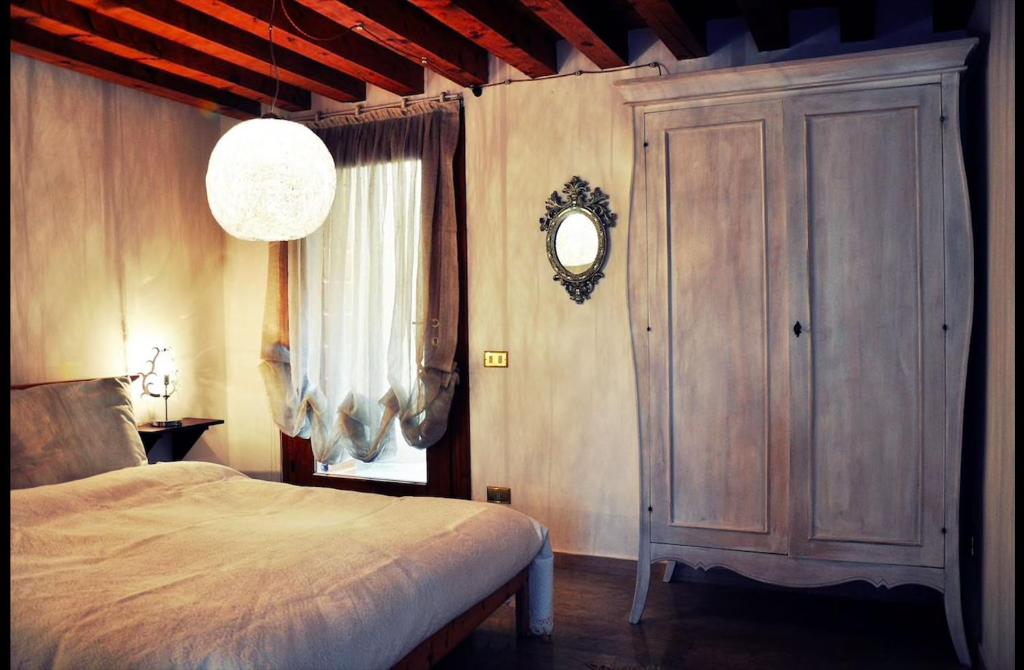 um quarto com uma cama e uma grande janela em Relais nel Castello em Bassano del Grappa