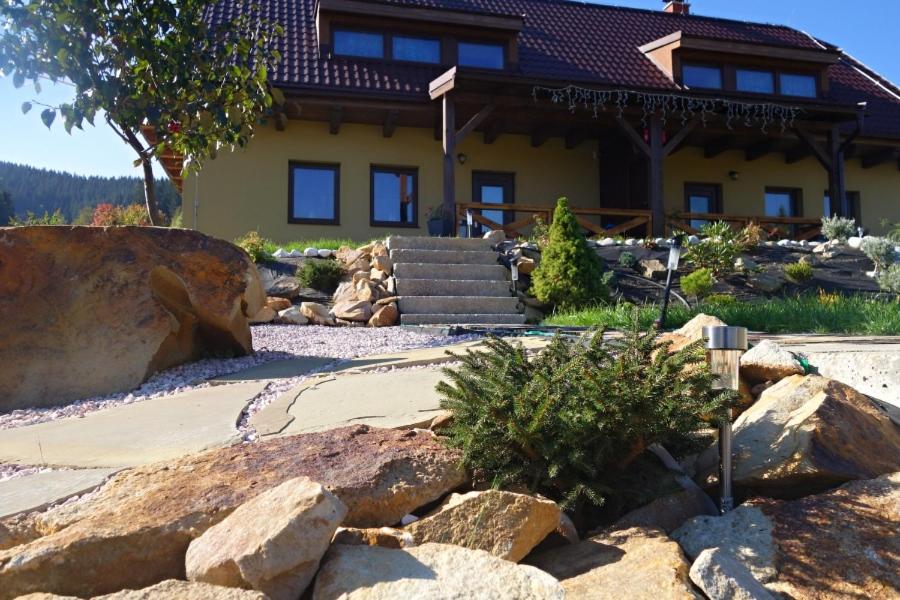 a house with a bunch of rocks in front of it at Apartmany Silverado in Horní Bečva