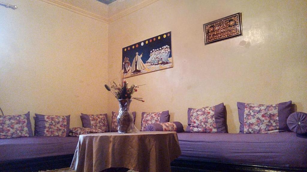 a living room with a purple couch and a table at Dar Al Taaj in Rabat