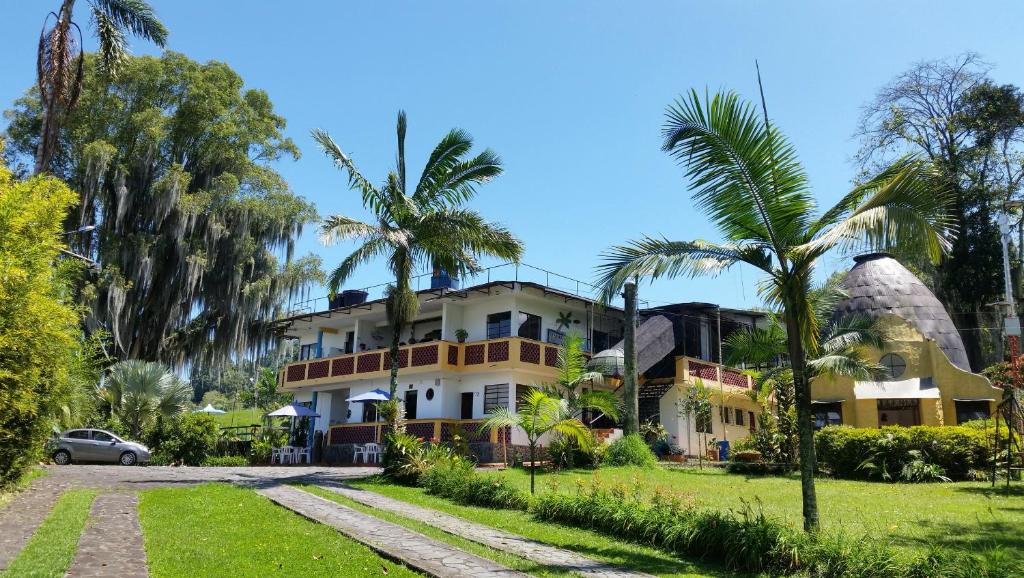 una casa con palmeras delante en Hotel Faroazul RNT12633, en Santa Rosa de Cabal