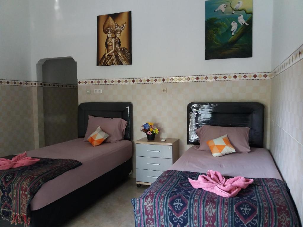 two beds sitting next to each other in a bedroom at citiz house & hostel in Nusa Penida