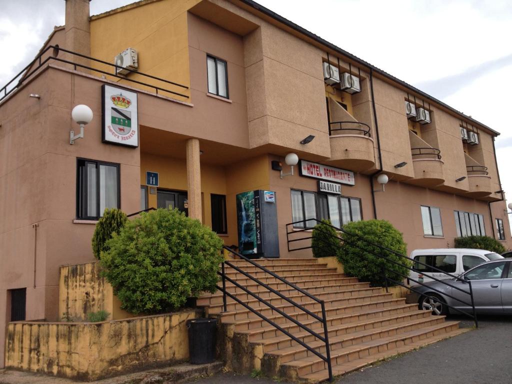 un edificio con escaleras y un coche aparcado delante en Hotel Restaurante Jarilla, en Jarilla