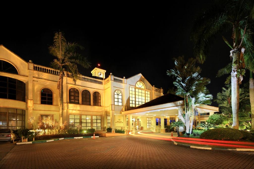 a large building with palm trees and a street at night at Tanjung Puteri Golf and Resort Malaysia in Pasir Gudang