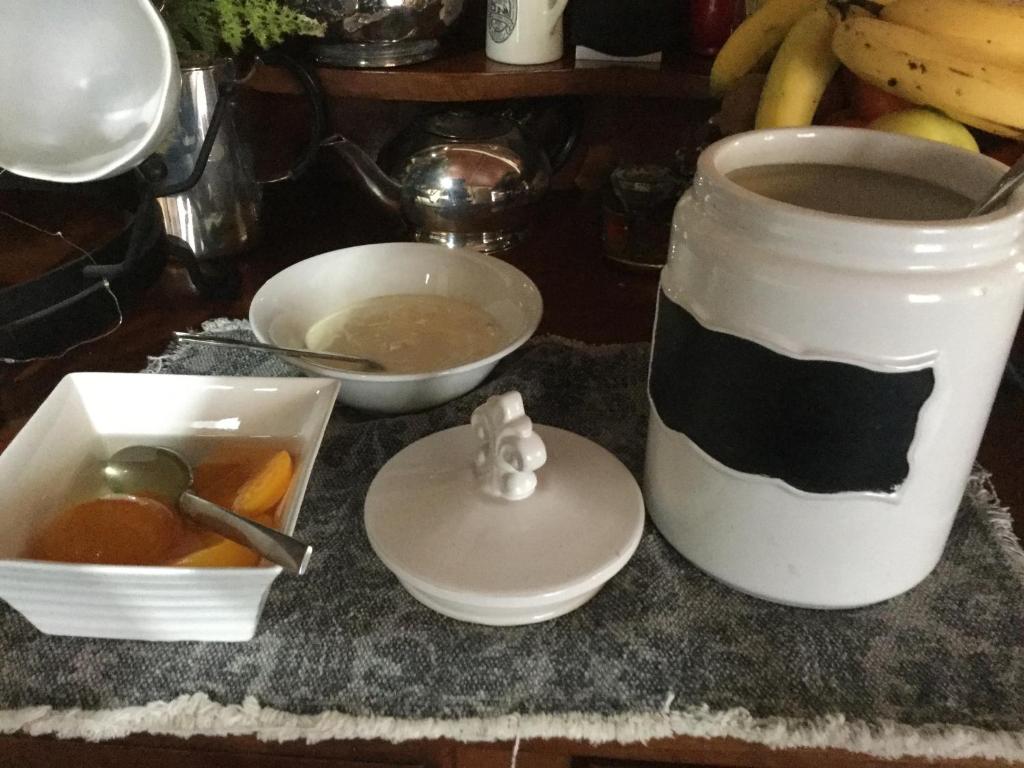 a table with a cup of coffee and a bowl of food at The Inn At The Convent in Taumarunui