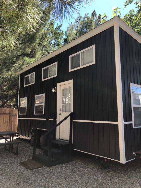 a black tiny house with a white door at Hygge Tiny Home HUE-gah in Leeds