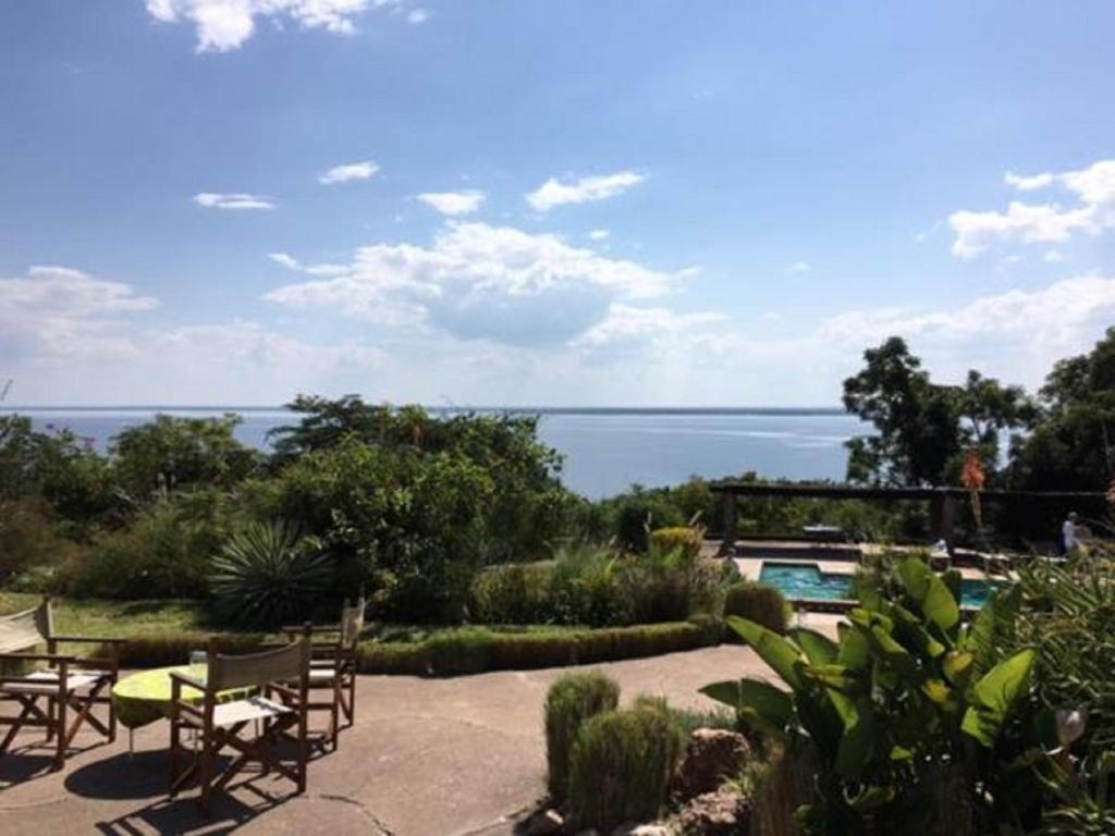 a patio with chairs and a view of the water at Musungwa Safari Lodge in Shanjungu