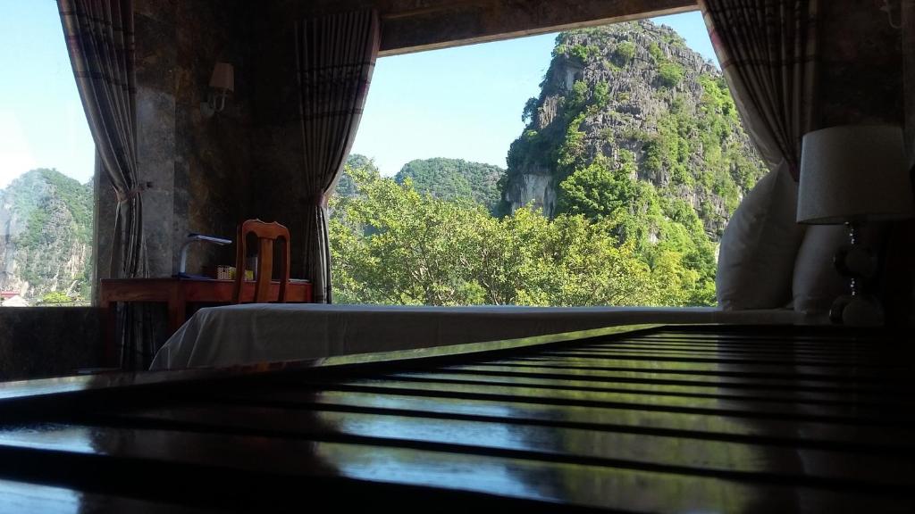 a room with a bed and a view of a mountain at Limestone View Homestay in Ninh Binh
