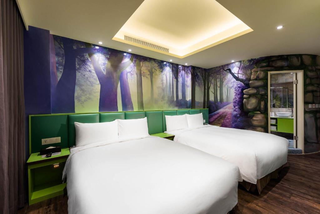 two beds in a room with a painting on the wall at Shichi Hotel in Kaohsiung