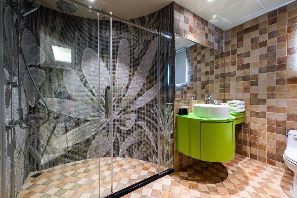 a bathroom with a shower with a sink and a toilet at Shichi Hotel in Kaohsiung