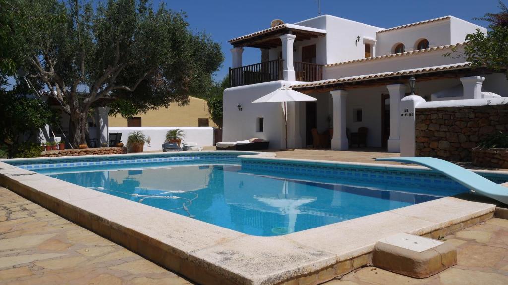 une villa avec une piscine en face d'une maison dans l'établissement Can Gat, à Sant Carles de Peralta