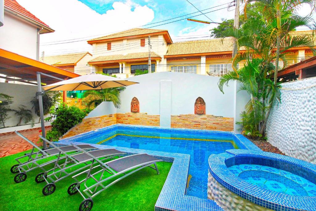 a house with a swimming pool next to a house at Grande Adam Private Pool Villa in Pattaya Central