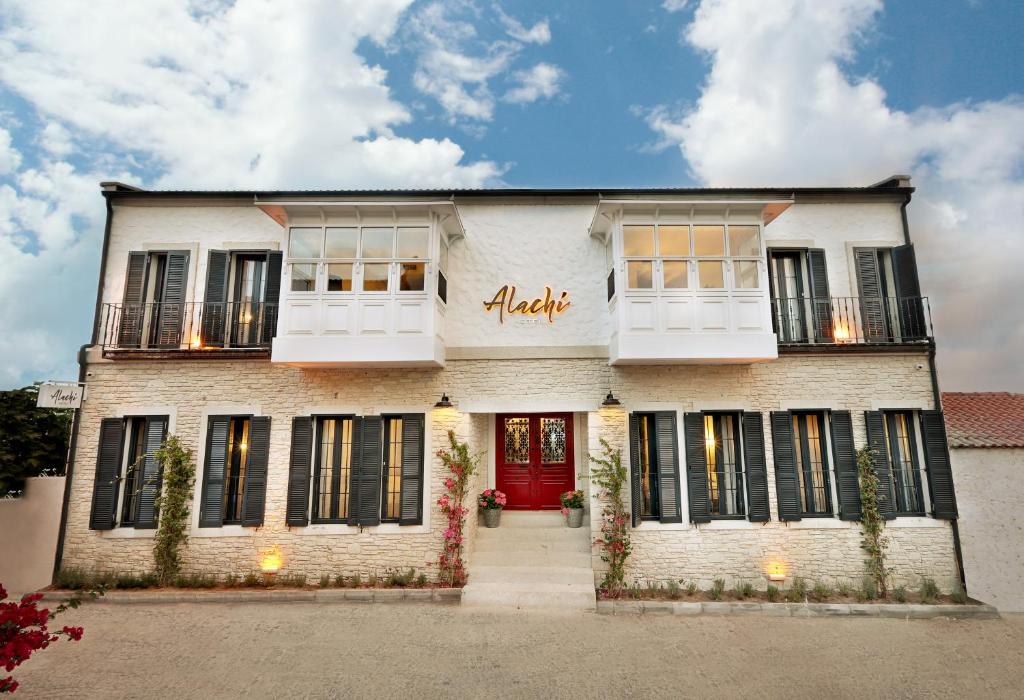 un edificio in mattoni bianchi con una porta rossa di Alachi Hotel ad Alaçatı