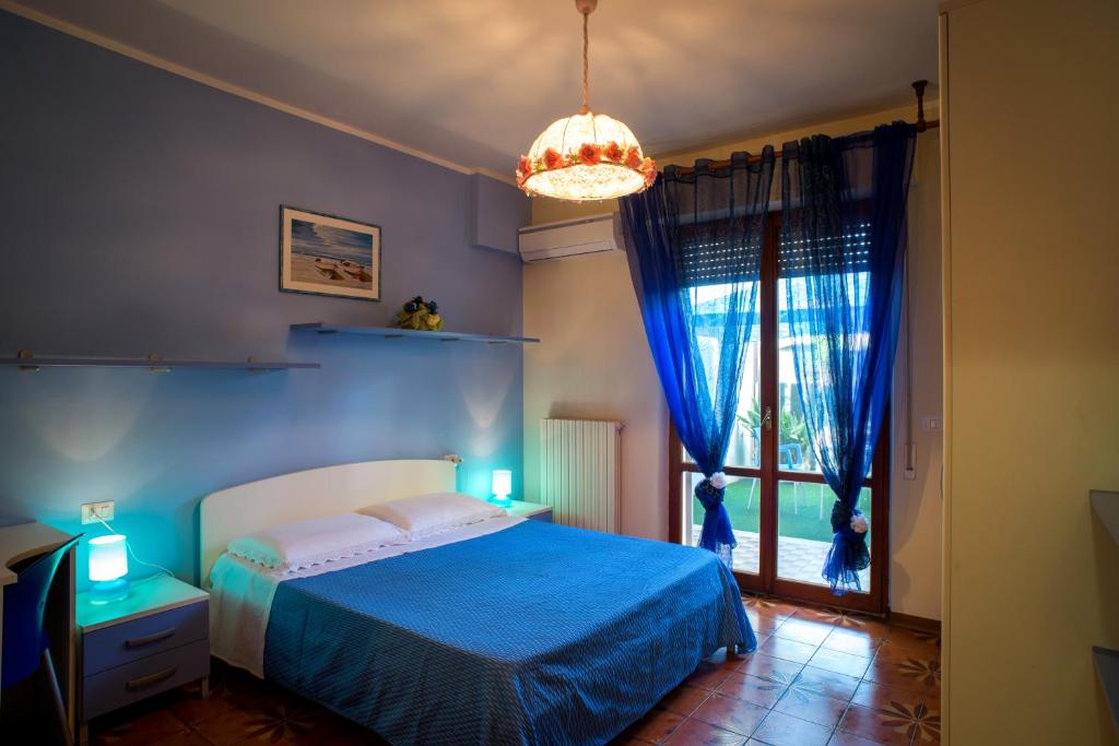 sypialnia z niebieskim łóżkiem i oknem w obiekcie BED AND BREAKFAST SAPORE DI MARE A 50 MT dalla SPIAGGIA w mieście Grottammare