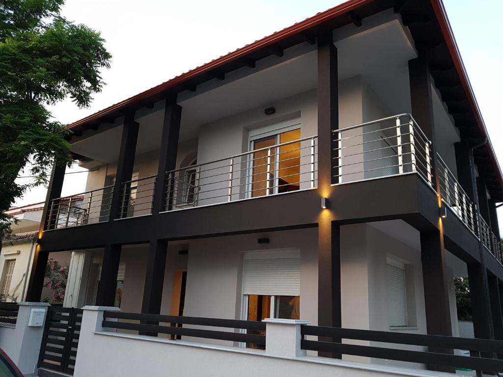 a large white house with a balcony at Fantastic Four Apartments in Neoi Epivates