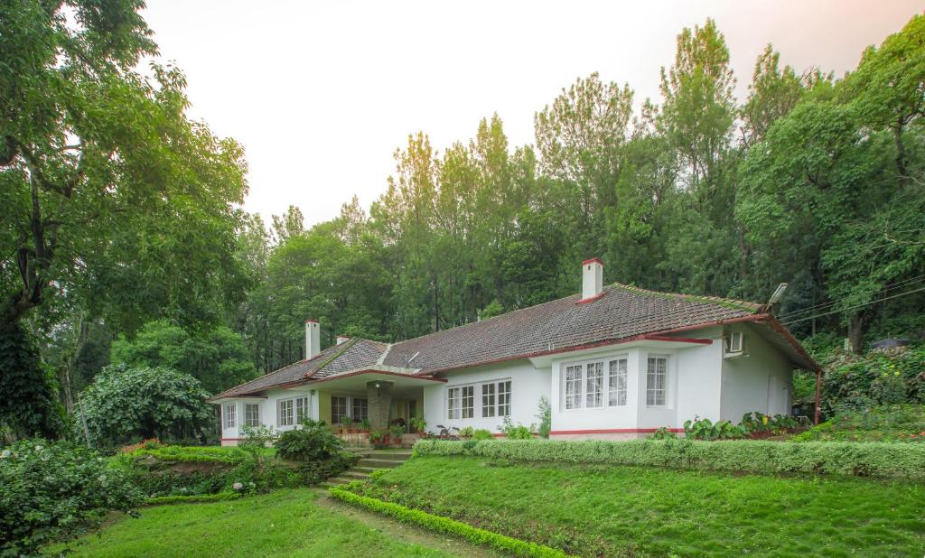 une maison blanche au milieu d'une cour dans l'établissement Ama Plantation Trails, Chikmagalur, à Chikmagalur