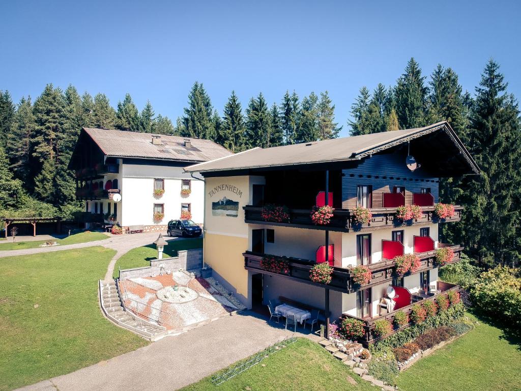 uma vista aérea de uma casa com vasos vermelhos em Pension Waldruh - Tannenheim em Faak am See