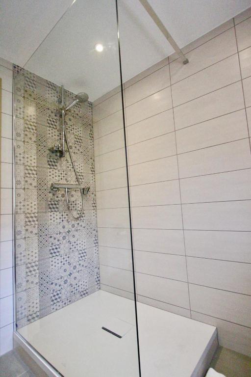 a shower with a glass door in a bathroom at Hotel Restaurant Le Maréchal - Teritoria in Colmar