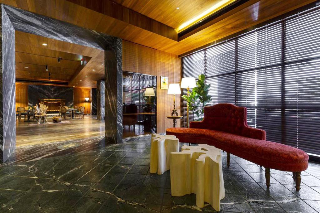 a lobby with a red chair and a large window at Inhouse Hotel Grand in Taichung