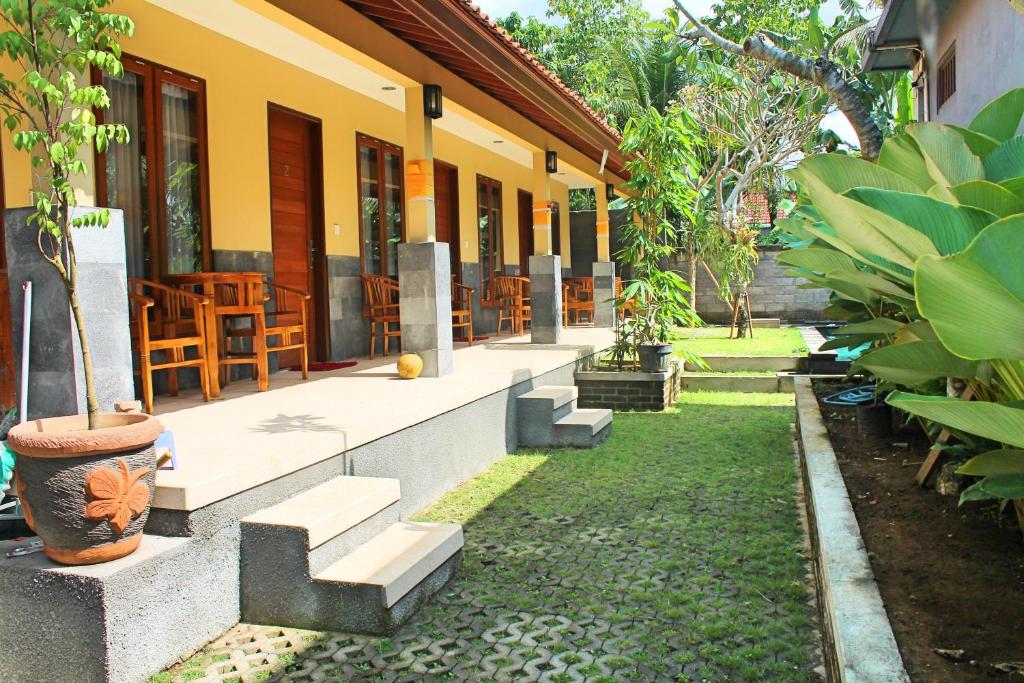 a building with stairs and tables and chairs at Werkudara Guest House in Ubud