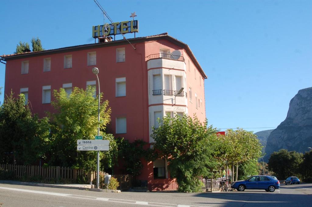 un edificio rojo con un cartel encima en Hotel Betriu en Coll de Nargó