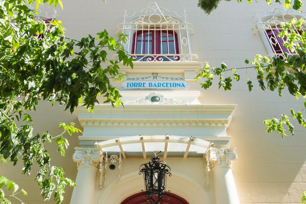 a white building with a sign above a door at Hotel Torre Barcelona in Sant Cugat del Vallès