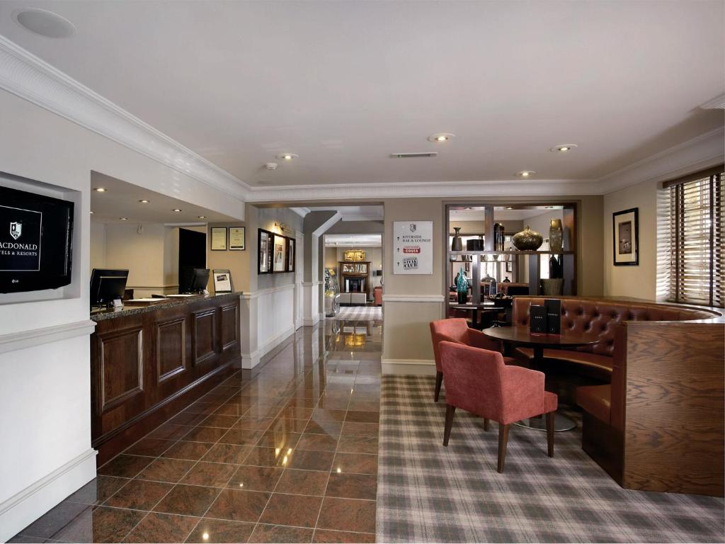 a dining room with a table and a bar at Macdonald Tickled Trout Hotel in Preston