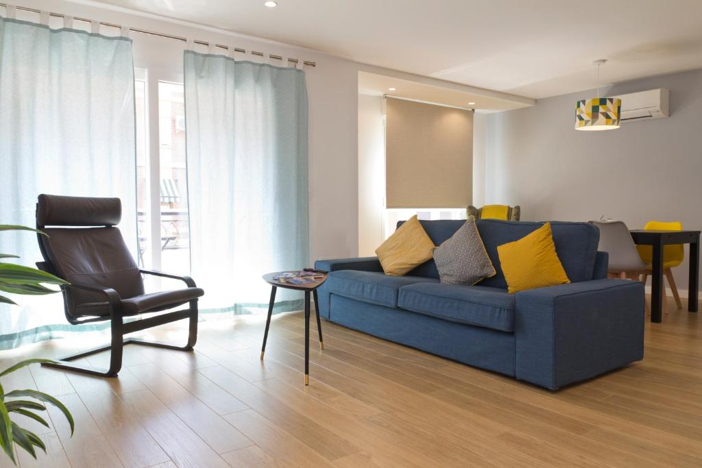 バレンシアにあるValencia Modern Beach Apartmentのリビングルーム(青いソファ、椅子付)