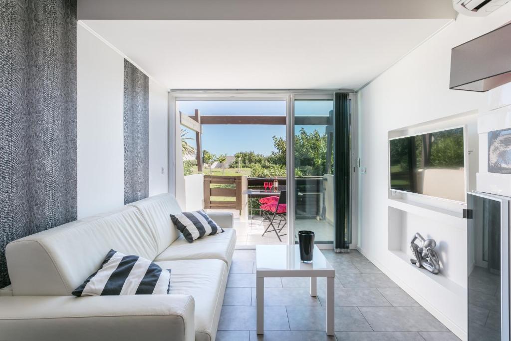 un salon avec un canapé et une table dans l'établissement Garden Port nature, au Cap d'Agde