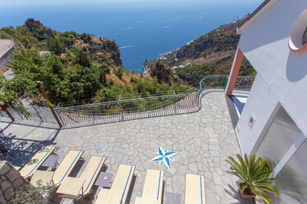 een patio met uitzicht op de oceaan vanuit een gebouw bij DOMUS VIGNA Fusco, Vista Mare, Amalfi Coast in Praiano