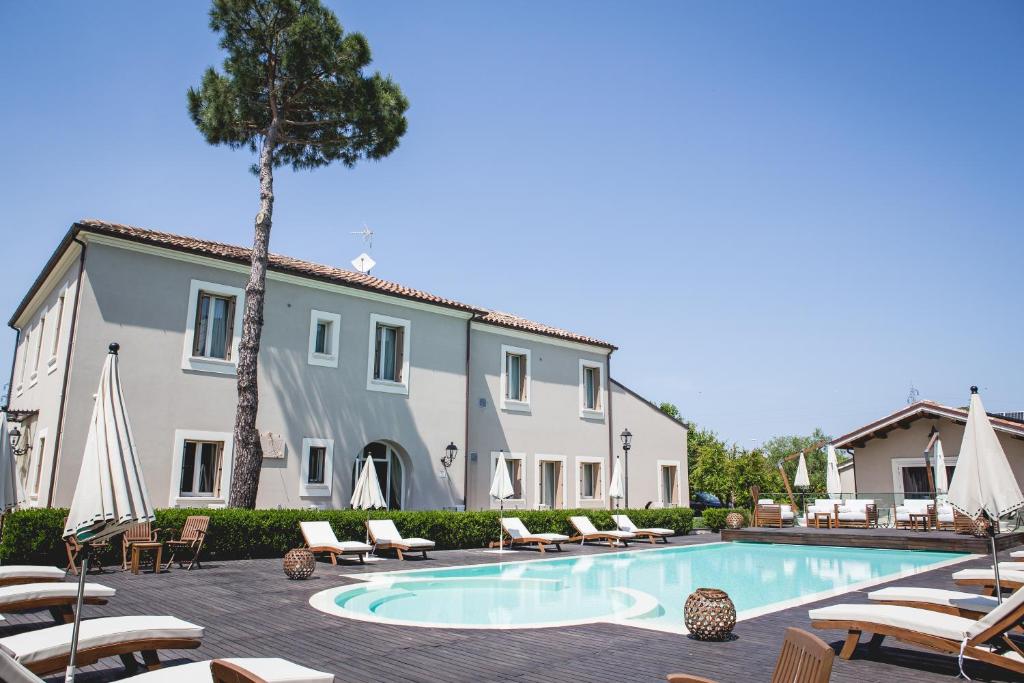 a villa with a swimming pool in front of a building at San Giovanni Relais in San Giovanni in Marignano