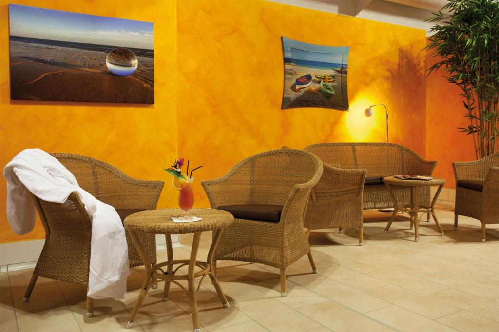 a dining room with wicker chairs and a table at Morada Strandhotel Ostseebad Kühlungsborn in Kühlungsborn