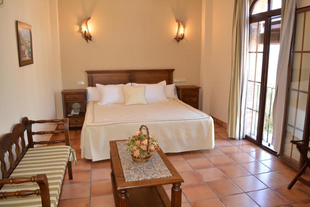 ウブリケにあるHotel Sierra de Ubriqueのベッドルーム1室(ベッド1台、テーブル、椅子付)