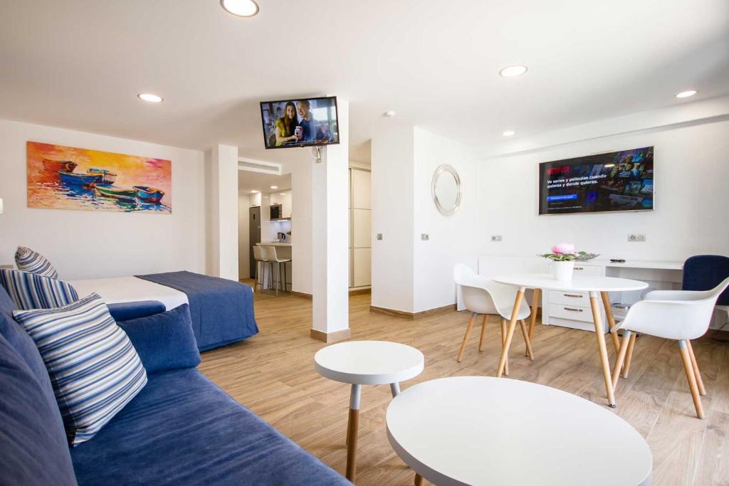 a living room with a blue couch and a table at IG Nachosol Atlantic & Yaizasol by Servatur - Adults Only in Puerto Rico de Gran Canaria